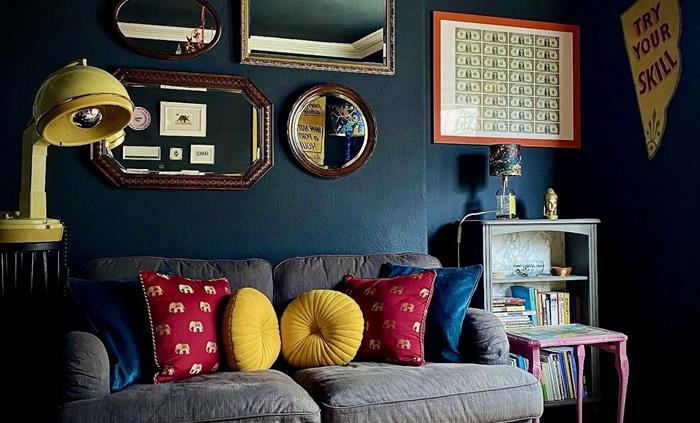 A lounge with black walls and mirrors on the wall